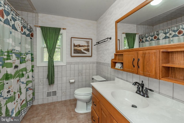 bathroom featuring tile floors, tile walls, toilet, and vanity