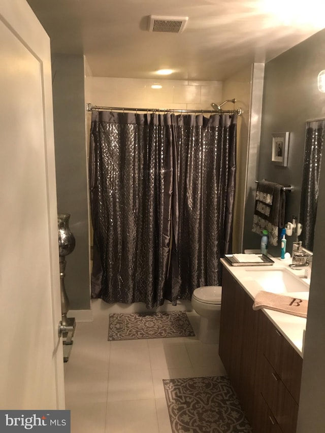 bathroom with toilet, tile floors, and vanity