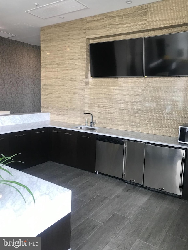 kitchen featuring backsplash, sink, and dishwasher