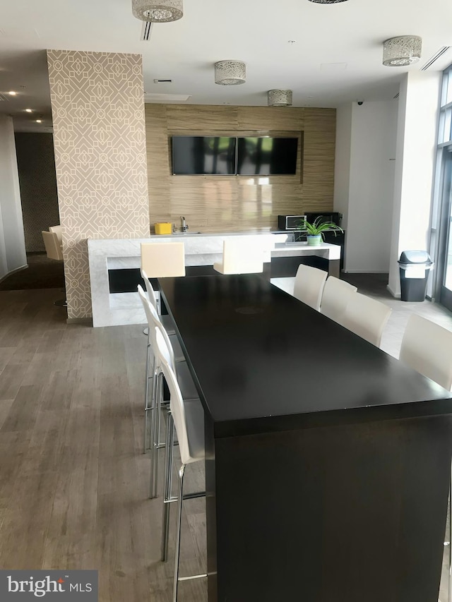 kitchen with a kitchen breakfast bar, sink, a kitchen island, and dark hardwood / wood-style flooring