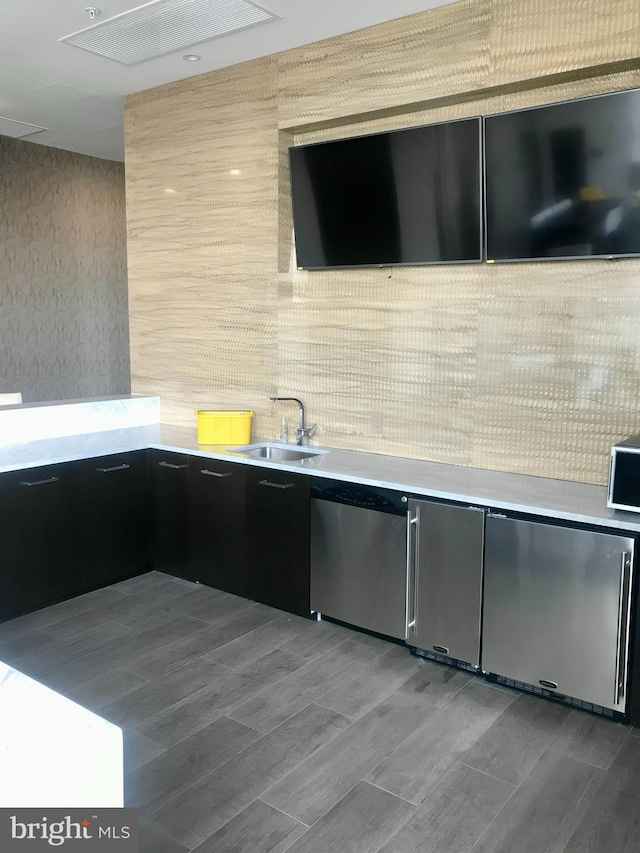 kitchen with stainless steel dishwasher, wood-type flooring, and sink