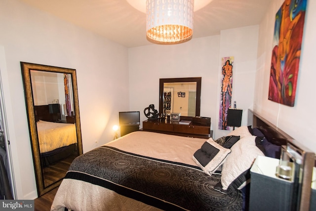 bedroom featuring dark hardwood / wood-style flooring and a chandelier