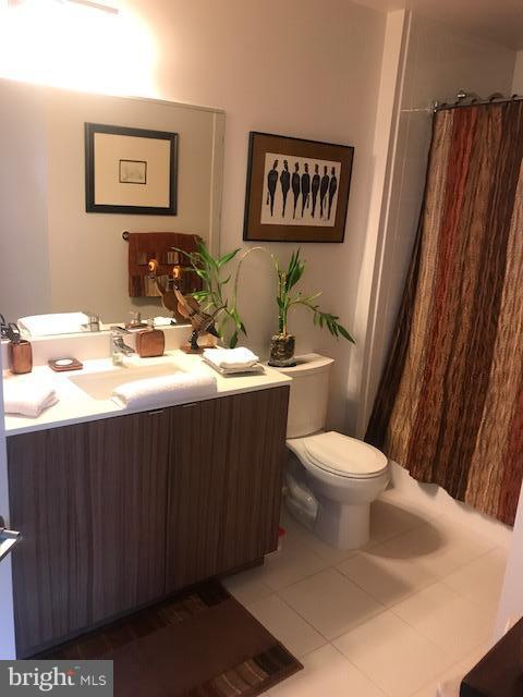 bathroom featuring tile flooring, toilet, and vanity