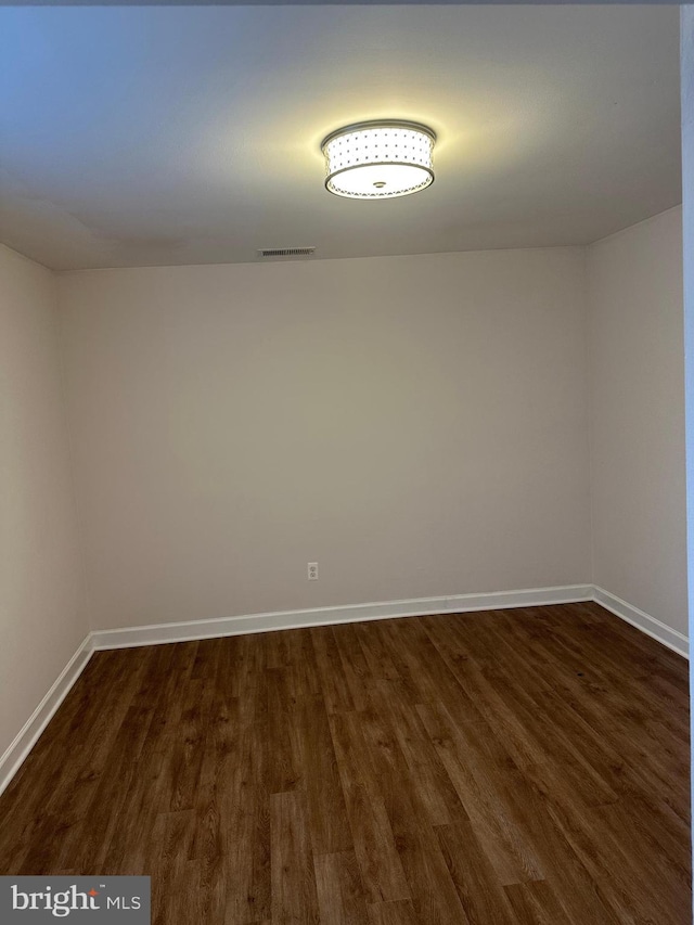 spare room featuring dark wood-type flooring