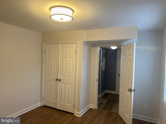 unfurnished bedroom with a closet and dark wood-type flooring