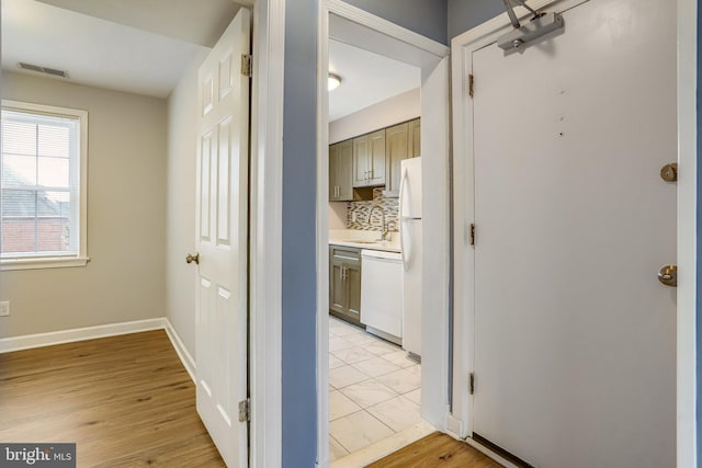 hall with light wood-type flooring and sink