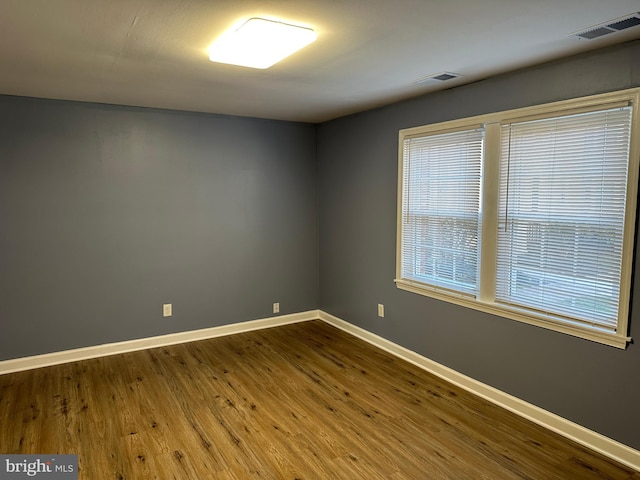 empty room with dark hardwood / wood-style flooring