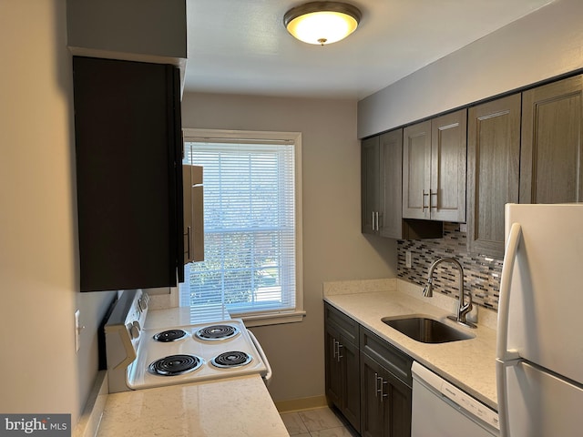 kitchen with tasteful backsplash, dark brown cabinets, white appliances, sink, and light tile flooring