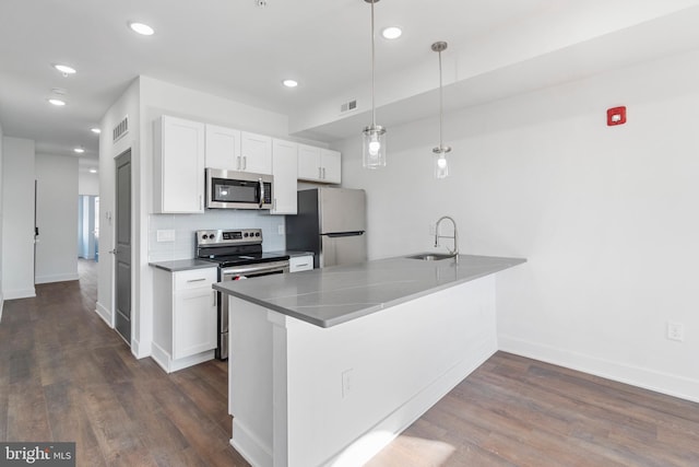 kitchen with pendant lighting, stainless steel appliances, dark hardwood / wood-style floors, and white cabinets