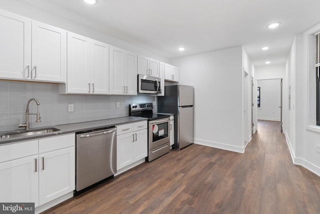 kitchen with dark hardwood / wood-style floors, tasteful backsplash, stainless steel appliances, and white cabinetry