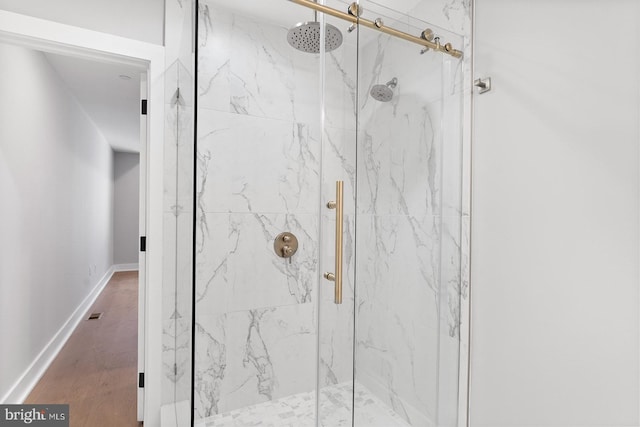 bathroom with hardwood / wood-style floors and a shower with shower door