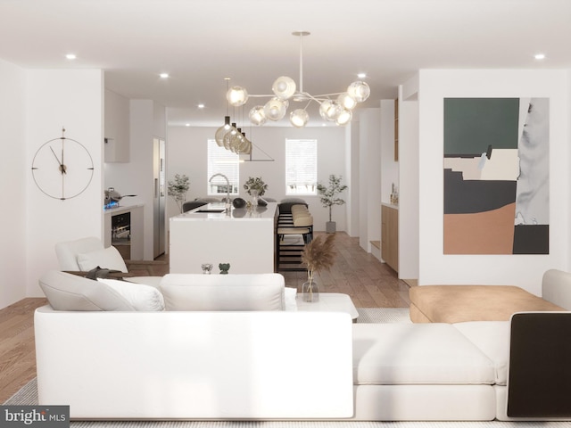 living room featuring sink, light wood-type flooring, and a notable chandelier