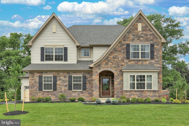 view of front of property with roof with shingles and a front yard