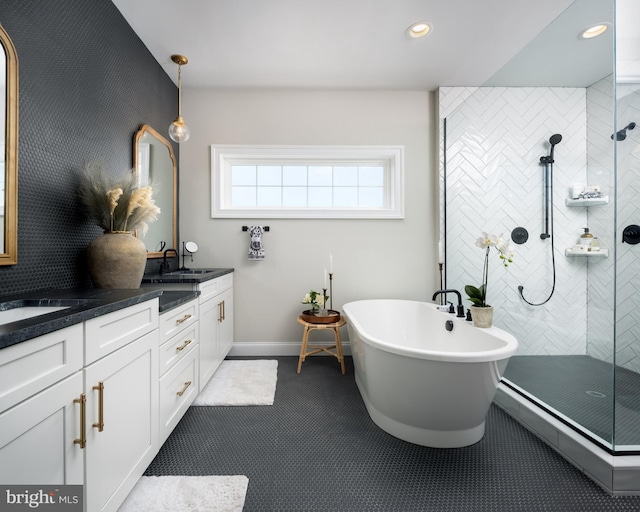 bathroom with a walk in shower, a freestanding tub, recessed lighting, baseboards, and double vanity