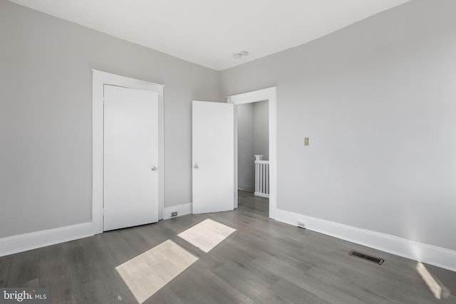 unfurnished bedroom with dark wood-type flooring