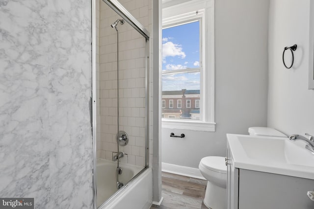 full bathroom with toilet, a wealth of natural light, hardwood / wood-style floors, and vanity