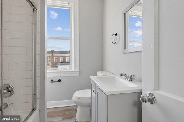 full bathroom featuring tiled shower / bath, toilet, vanity, and wood-type flooring