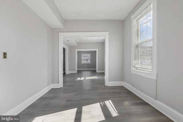 empty room with plenty of natural light and dark hardwood / wood-style floors