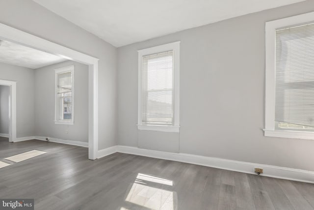 unfurnished room with dark hardwood / wood-style flooring and a wealth of natural light