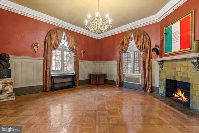 living room featuring a chandelier, parquet floors, a tile fireplace, and ornamental molding