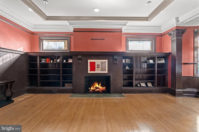 living room featuring a raised ceiling, ornamental molding, and wood-type flooring