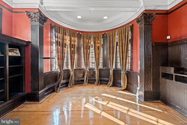 interior space featuring crown molding, decorative columns, and light parquet floors