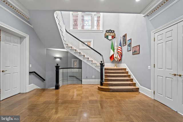 entrance foyer with light parquet flooring and a towering ceiling