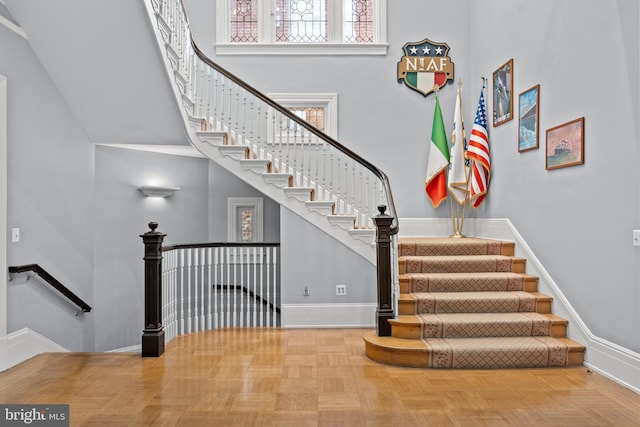 stairway featuring a towering ceiling