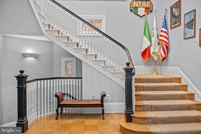 stairs with light parquet flooring and a wealth of natural light