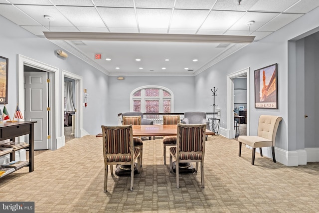 dining area with a drop ceiling and light colored carpet