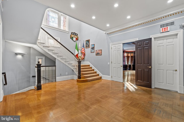 entrance foyer featuring light parquet flooring and a high ceiling