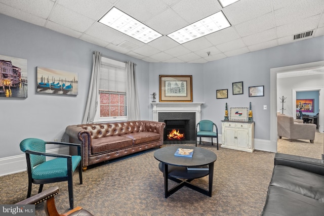 carpeted living room with a drop ceiling