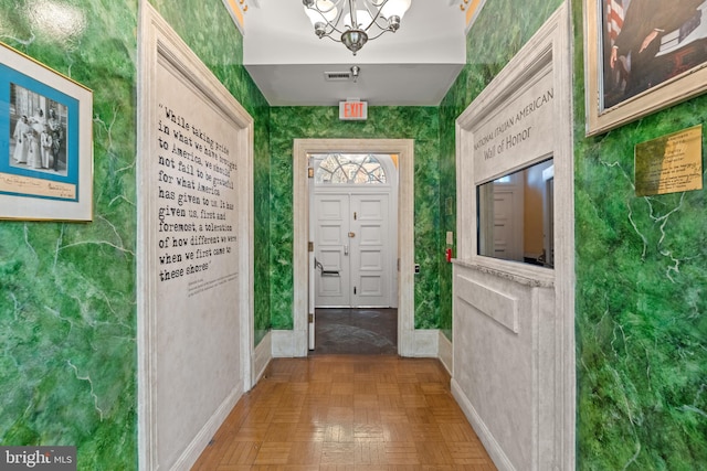 interior space with dark parquet floors and a notable chandelier