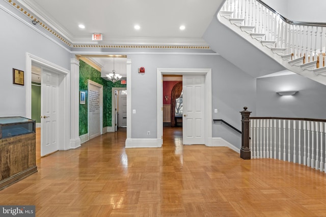 interior space featuring light parquet floors, a notable chandelier, a towering ceiling, and crown molding