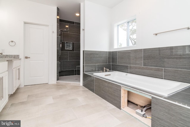 bathroom featuring independent shower and bath, tile patterned floors, and vanity