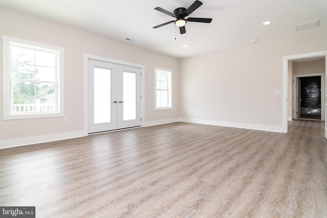 unfurnished living room featuring light hardwood / wood-style flooring, ceiling fan, and french doors