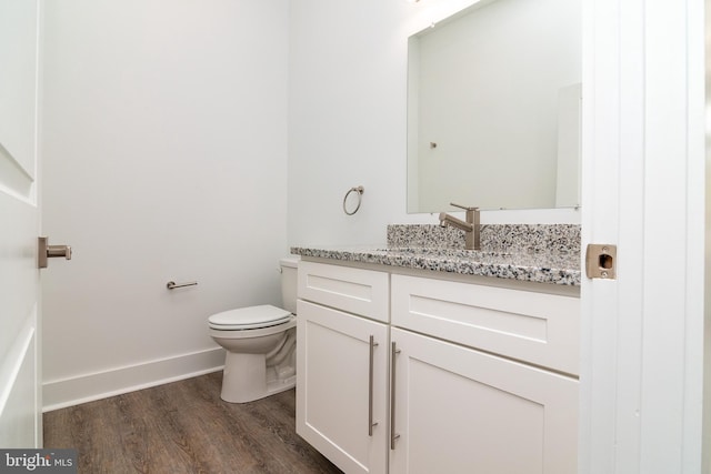 bathroom featuring vanity, toilet, and hardwood / wood-style floors