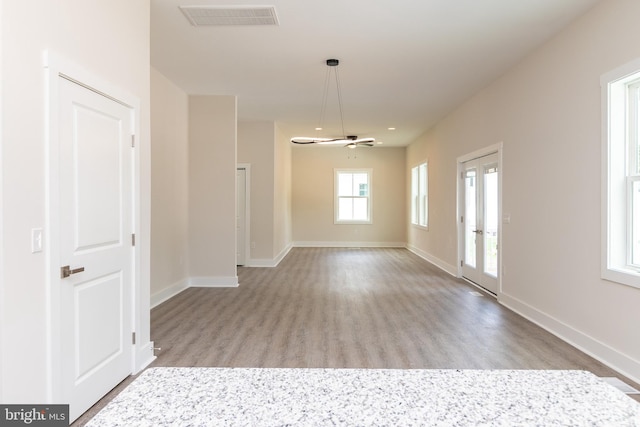 unfurnished living room with a healthy amount of sunlight, light hardwood / wood-style floors, and ceiling fan