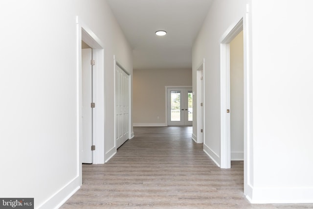 hallway featuring french doors and light wood-type flooring