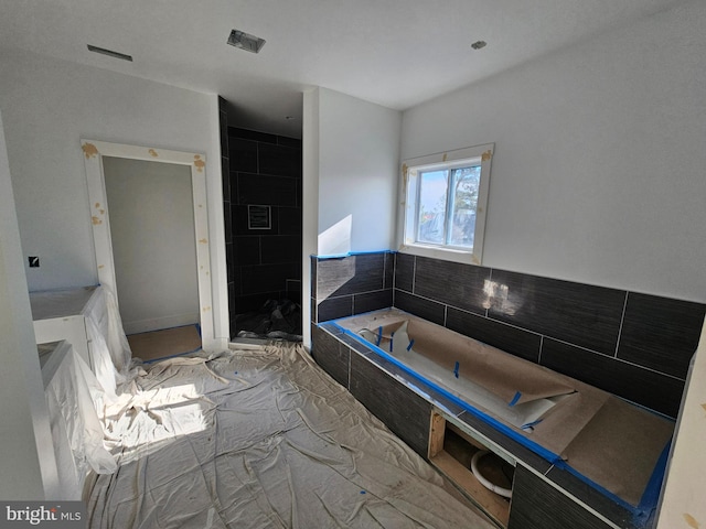 bathroom featuring a relaxing tiled tub