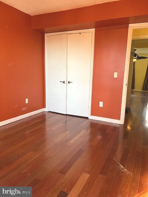 unfurnished bedroom with a closet and dark hardwood / wood-style floors