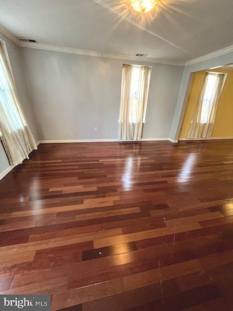 empty room with dark hardwood / wood-style floors and ornamental molding