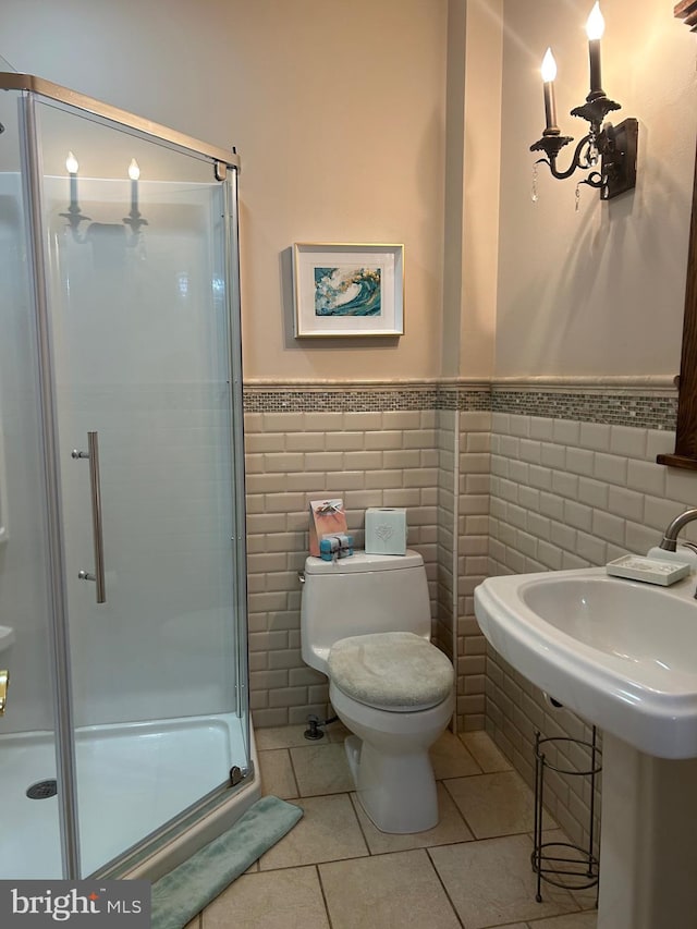 bathroom with tile walls, walk in shower, toilet, and tile floors