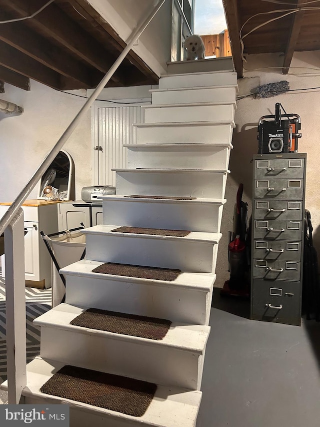 staircase featuring concrete flooring