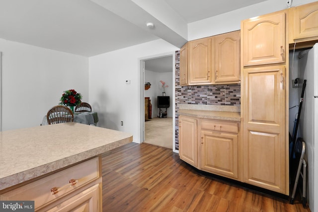 kitchen featuring backsplash, light brown cabinets, and dark colored carpet