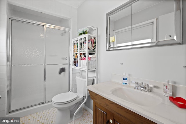 bathroom featuring toilet, tile floors, large vanity, and a shower with shower door