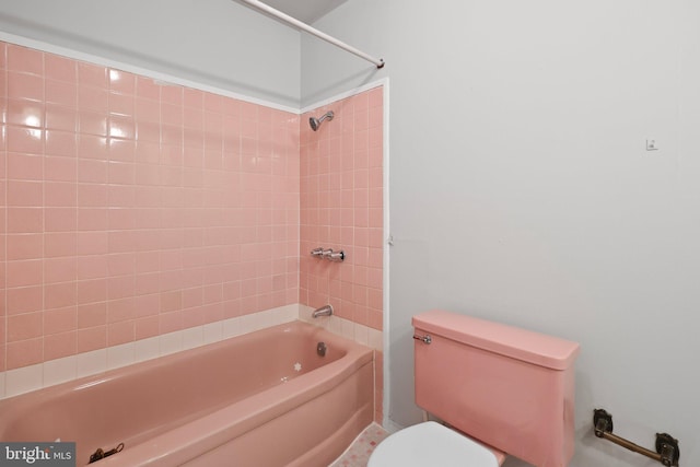 bathroom with toilet and tiled shower / bath