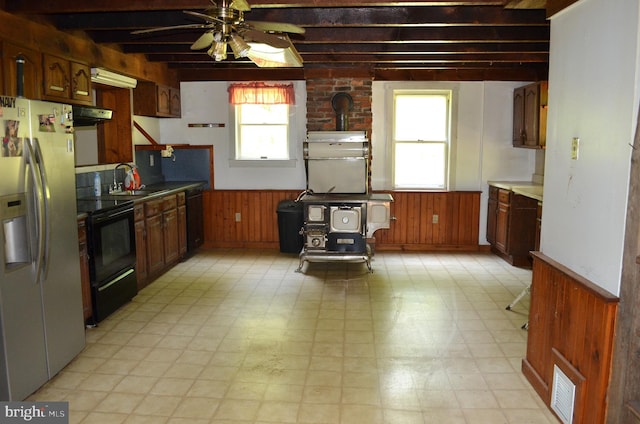 kitchen with light tile patterned flooring, beamed ceiling, ceiling fan, and black appliances