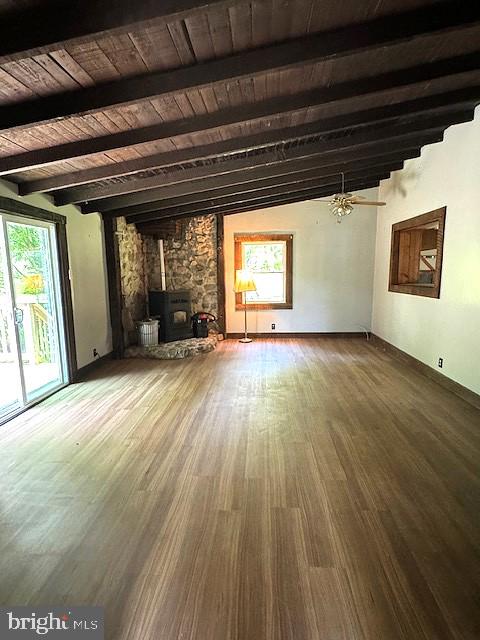 unfurnished living room with a wood stove, hardwood / wood-style flooring, and wood ceiling