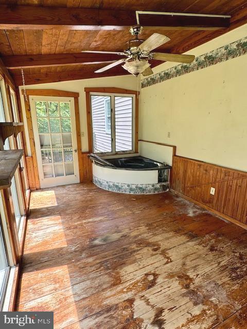 unfurnished living room featuring wood ceiling, ceiling fan, wood-type flooring, and vaulted ceiling with beams